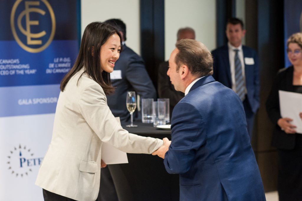 A woman and man shaking hands at a conference.