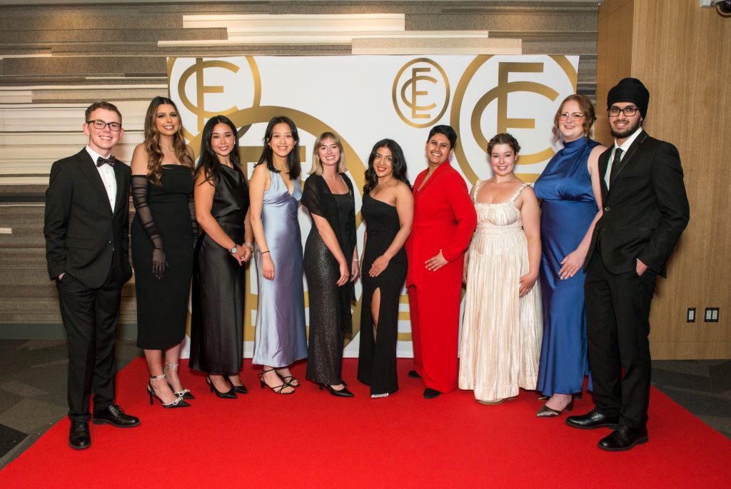 People standing on a red carpet for a group shot.