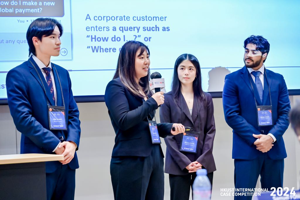 Four standing presenters with one speaking.