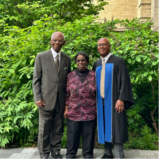 Group photo of three people standing in the centre