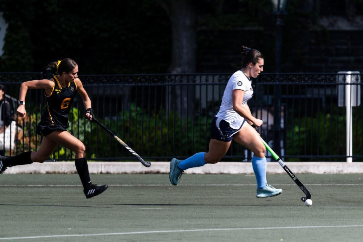 Varsity athlete Elizabeth Assimes handles the ball during a field hockey game.